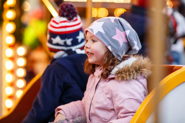 Little boy and girl, siblings on carousel at Christmas market — Stock Photo, Image