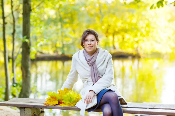 Joyeux jeune femme avec guirlande de feuilles d'érable d'automne dans le parc . — Photo