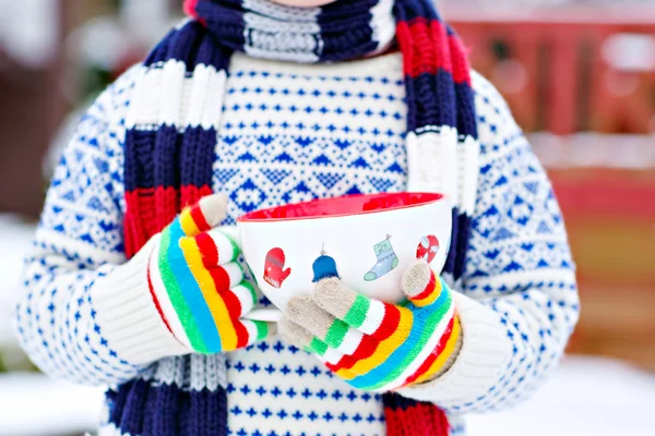 Manos de niño pequeño sosteniendo gran taza con copos de nieve y ch caliente —  Fotos de Stock