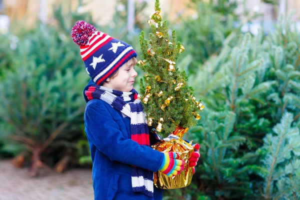 Hermoso niño sonriente sosteniendo el árbol de Navidad —  Fotos de Stock