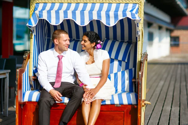 美丽印度新郎和新娘白种人在沙滩椅. — 图库照片