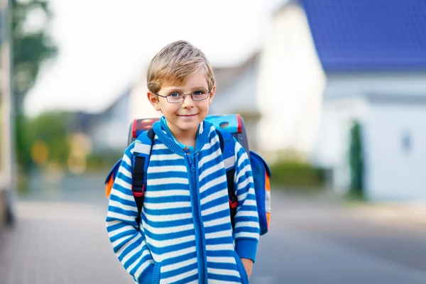 Маленький мальчик со школьной сумкой по дороге в школу — стоковое фото