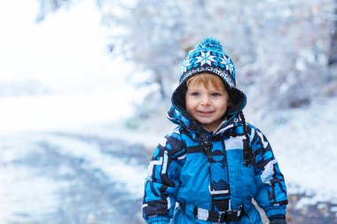 Mutlu çocuk kışın kar ile eğleniyor