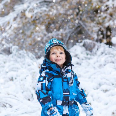 Mutlu çocuk kışın kar ile eğleniyor