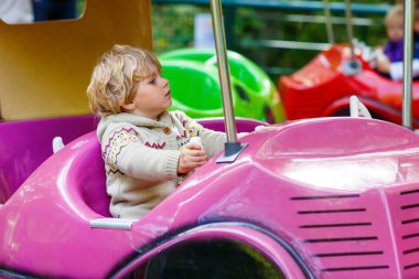 Küçük çocuk çocuk eğlence parkı atlıkarınca üstünde