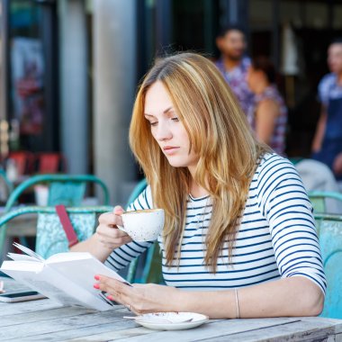 Kahve içme ve kafede kitap okuma kadın