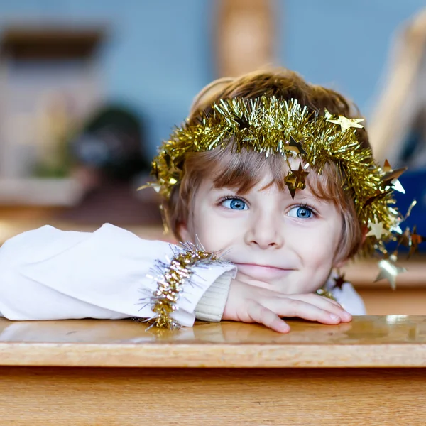 Menino pequeno jogando um anjo da história de Natal na igreja — Fotografia de Stock