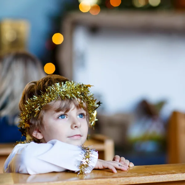 Menino pequeno jogando um anjo da história de Natal na igreja — Fotografia de Stock