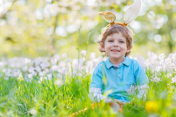 Niño pequeño con orejas de conejo de Pascua en primavera —  Fotos de Stock