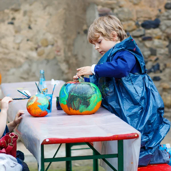 Menino e menina pintura com cores na abóbora — Fotografia de Stock