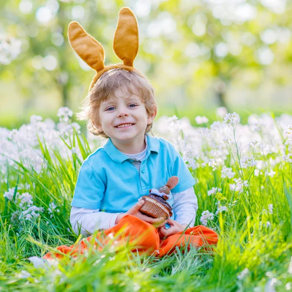 Petit garçon enfant avec des oreilles de lapin de Pâques et cupcake — Photo