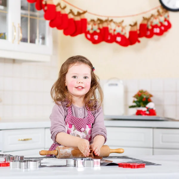 Malá holčička pečení perníku cookie v domácí kuchyni — Stock fotografie