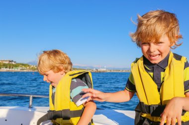 two little kid boys enjoying sailing boat trip