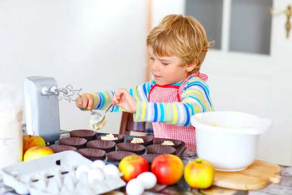 Engraçado menino loiro cozinhando bolo de maçã dentro de casa — Fotografia de Stock