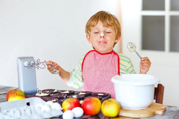 Funny blond kid boy baking apple cake indoors — Stock Photo, Image