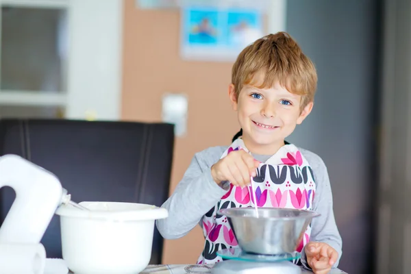 Divertente ragazzo biondo che cuoce torta al chiuso — Foto Stock