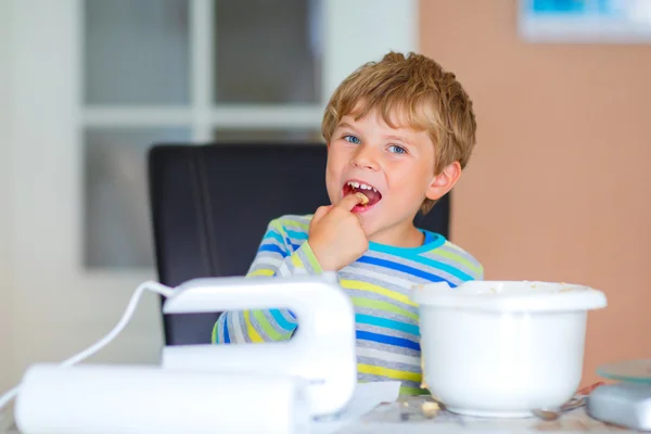 Счастливый блондин мальчик печет торт в помещении — стоковое фото