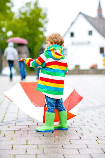 Mały chłopiec dziecko chodzenie z duży parasol na dworze — Zdjęcie stockowe