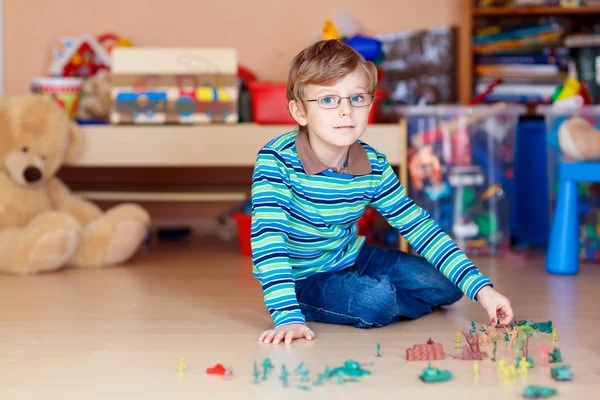 Dziecko, chłopiec bawi się zabawkami żołnierzy pomieszczeniu w przedszkolu — Zdjęcie stockowe