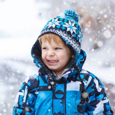 Mutlu çocuk kışın kar ile eğleniyor