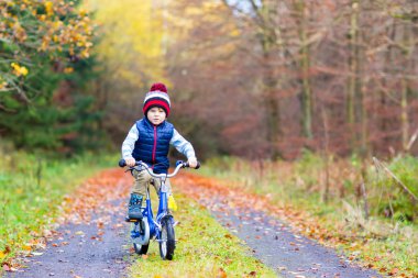 Küçük çocuk çocuk sonbahar ormandaki bisiklet ile