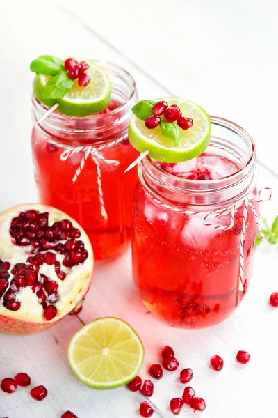 Two glasses with red pomgranate juice, lemon and mint. — Stock Photo, Image