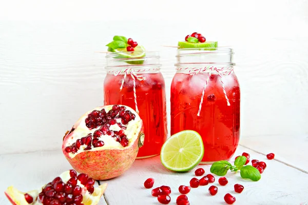 Twee glazen met rode pomgranate SAP, citroen en munt. — Stockfoto