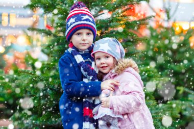 İki küçük çocuk Noel piyasasında sarılma