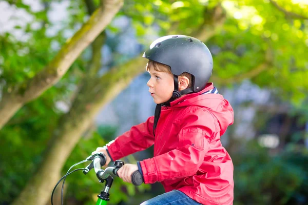 Little preschool kid boy in helmet biking on bicycle in the autu — Stock Photo, Image