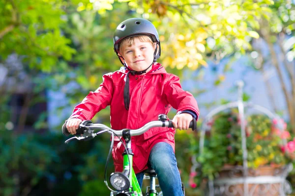 Liten förskola kid pojke i hjälmen cykling på cykel i hös — Stockfoto