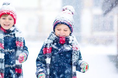 Mutlu çocuklar kışın karla eğleniyor.