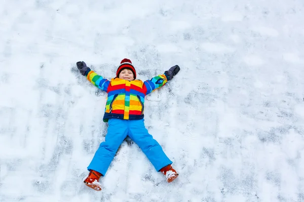 小家伙在冬天，在户外做雪天使的男孩 — 图库照片