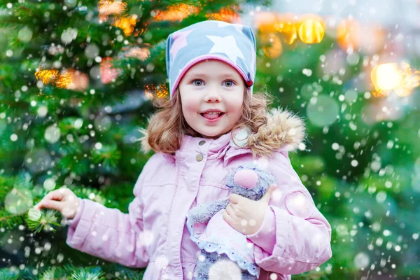 Hermosa niña sonriente sosteniendo el árbol de Navidad —  Fotos de Stock