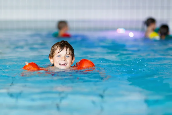 Çocuk çocuk swimmies bir kapalı havuzda yüzmek için öğrenme ile — Stok fotoğraf