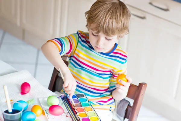 Kid jongetje kleuren eieren voor paasvakantie — Stockfoto