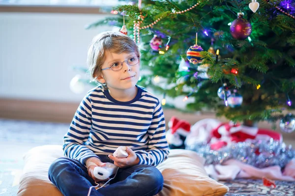 Маленький мальчик играет в видеоигры на Рождество — стоковое фото
