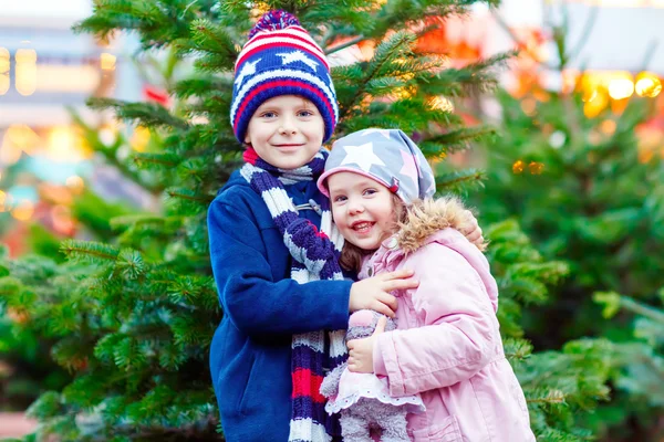 Duas crianças abraçando no mercado de Natal — Fotografia de Stock