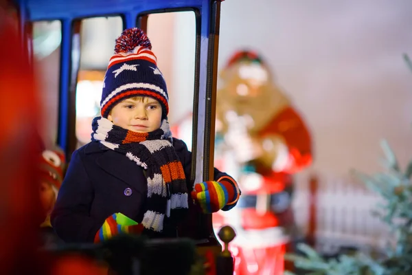 Niño pequeño en carrusel en el mercado de Navidad — Foto de Stock