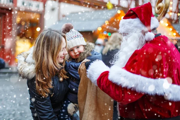 Anneyle Noel piyasasında küçük yürümeye başlayan çocuk kız. — Stok fotoğraf