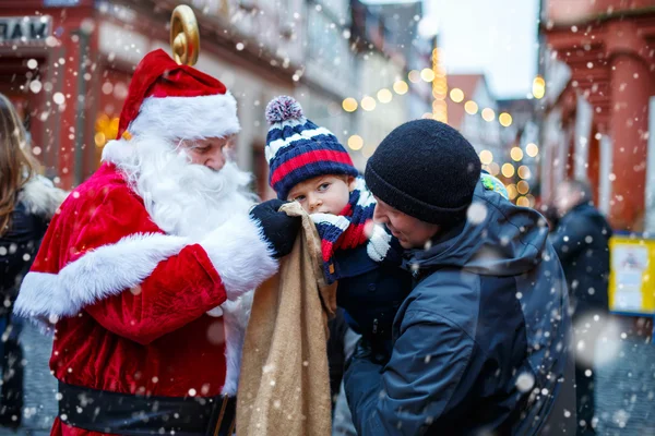 Malý chlapec batole s otcem a Santa Claus na vánoční trh — Stock fotografie