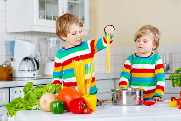 Twee kid beetje jongens koken van pasta met groenten — Stockfoto