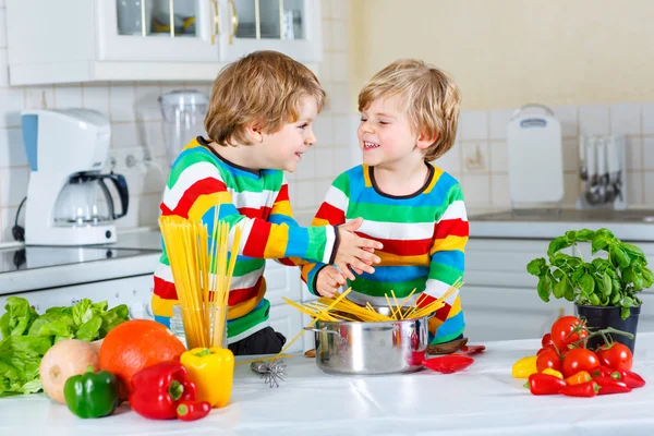 Zwei kleine Jungen kochen Nudeln mit Gemüse — Stockfoto