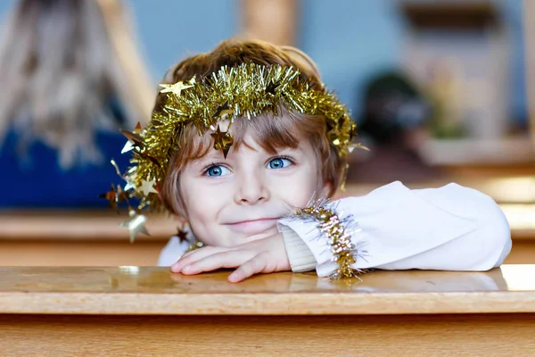 Menino pequeno jogando um anjo da história de Natal na igreja — Fotografia de Stock