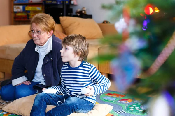 Little kid boy and grandmother playing video game console — Stock Photo, Image