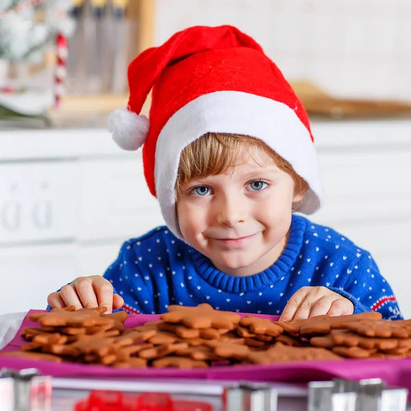 Beetje kid jongen kerstkoekjes thuis bakken — Stockfoto