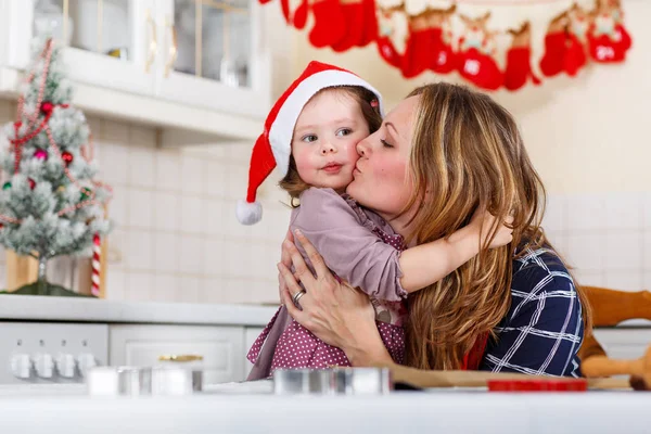 母親と小さな子供女の子クリスマスのジンジャーブレッドのクッキーを焼く — ストック写真