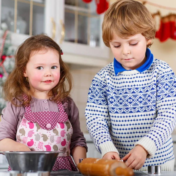 Jongen en meisje kerstkoekjes thuis bakken — Stockfoto