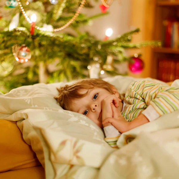 Kleiner süßer blonder Junge schläft unter dem Weihnachtsbaum — Stockfoto
