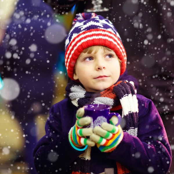 Niño pequeño con chocolate caliente en el mercado de Navidad — Foto de Stock