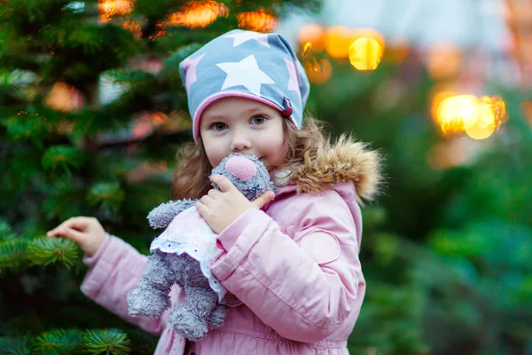 Beautiful smiling little girl holding christmas tree — Stock Photo, Image